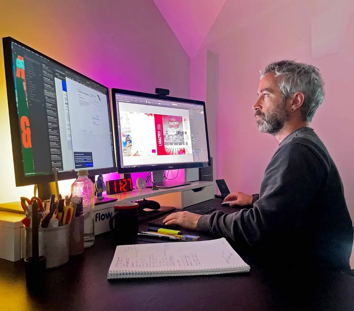 Asier de ab'studio trabajando en diseño gráfico frente a dos monitores