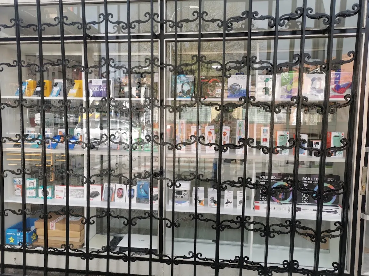 Escaparate de Abadiño Móviles y Ordenadores con productos electrónicos tras una reja
