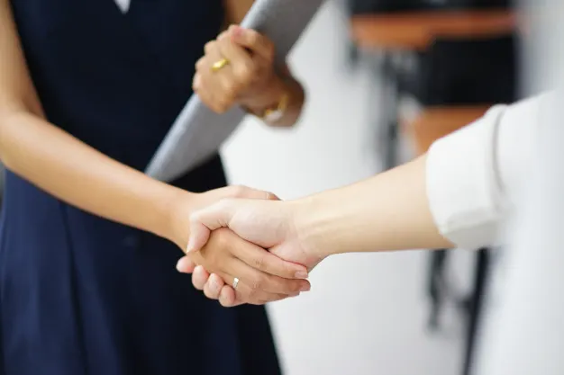 Personas estrechándose la mano en una reunión, imagen asociada a Abogada Ana Bilbao