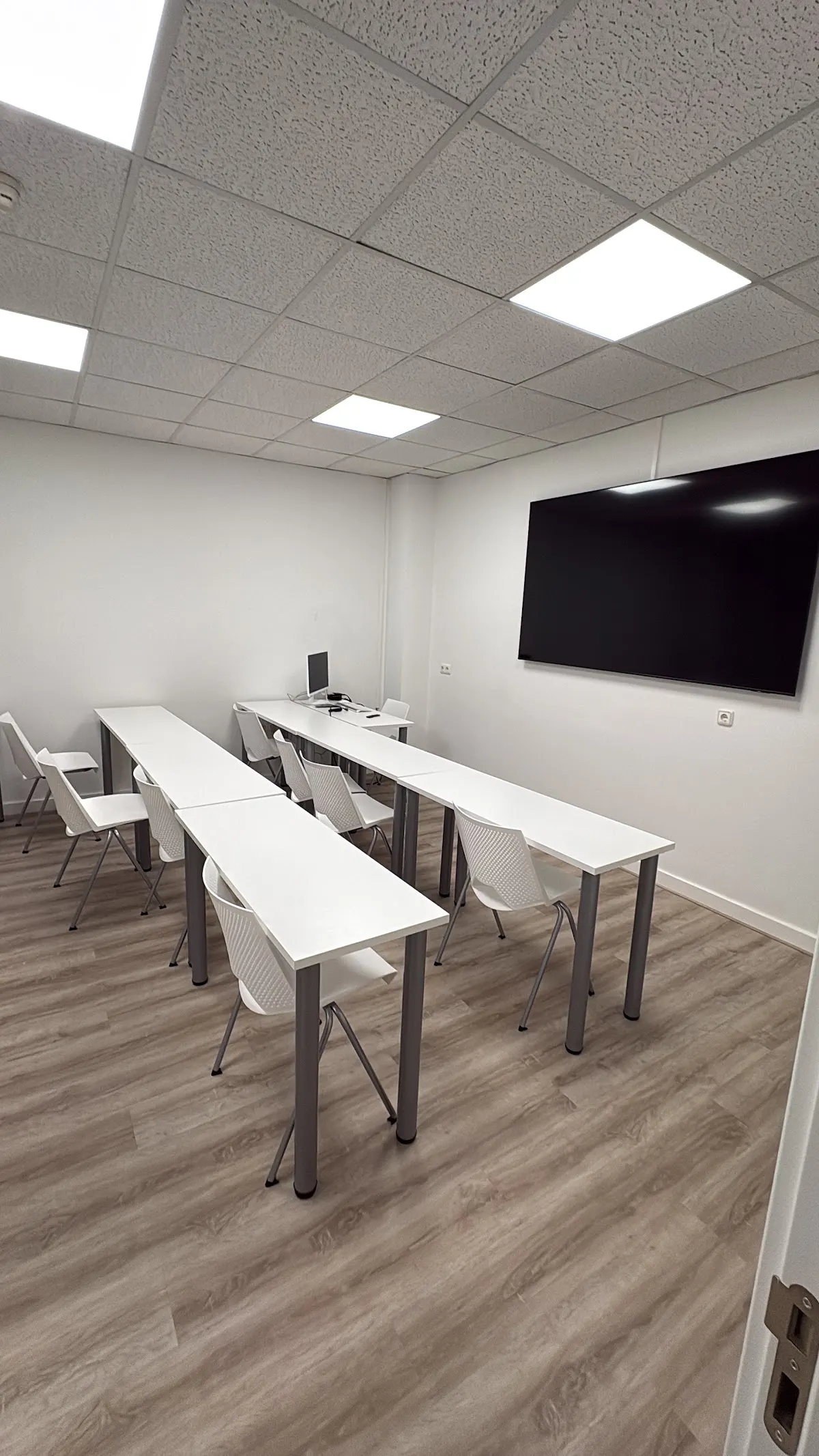 Aula de Academia Seiko con mesas y pantalla