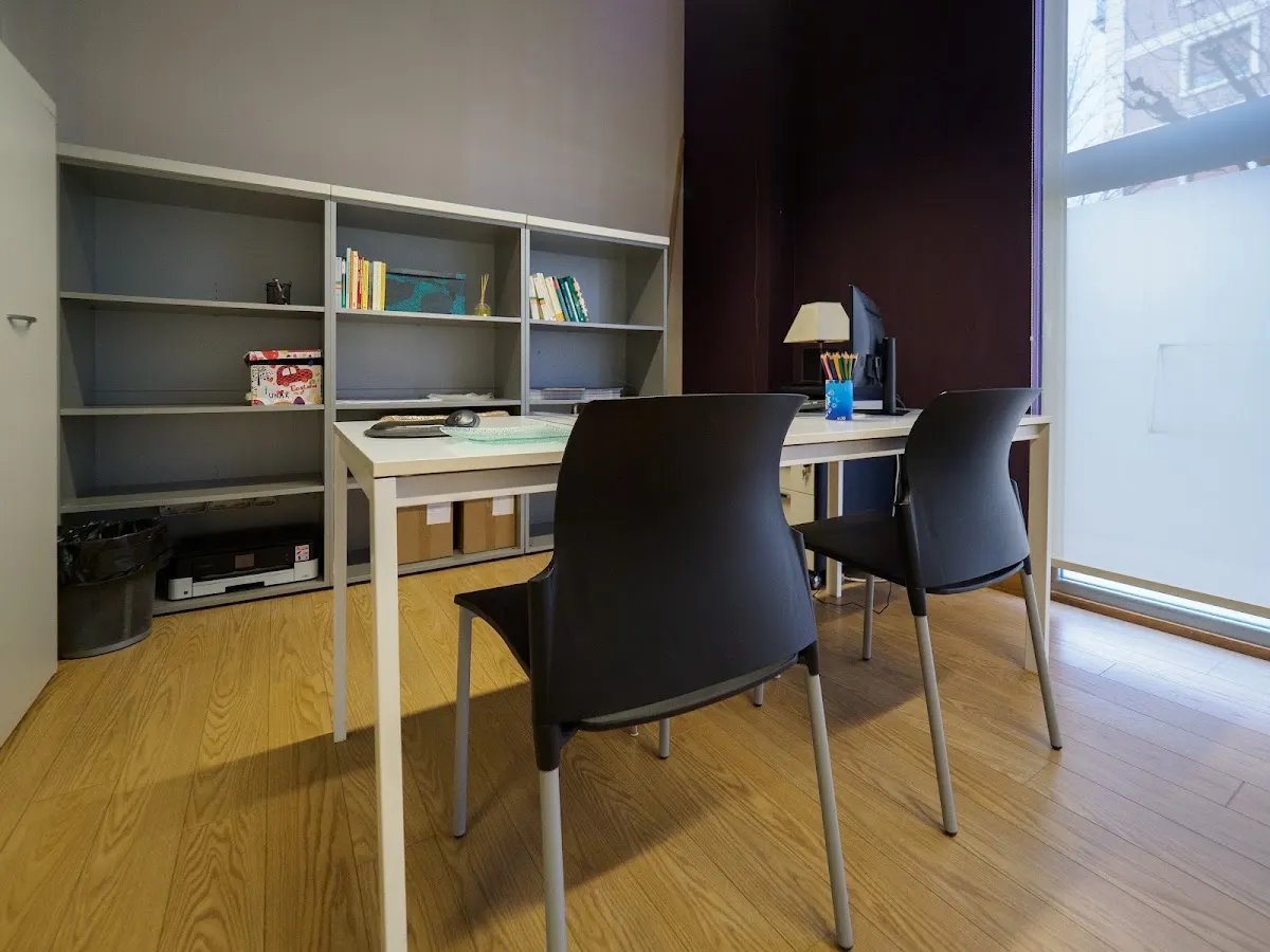 Interior de Adeitu Psikologia con mesa, sillas y estanterías.
