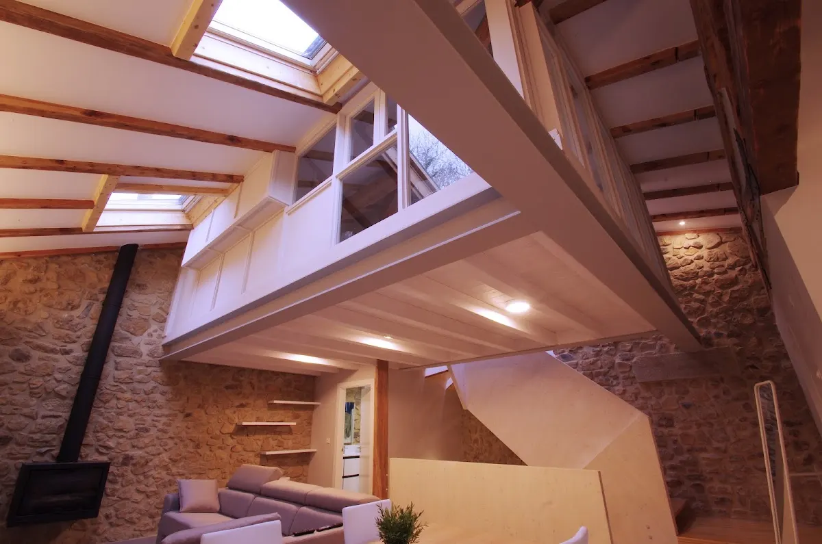 Interior reformado con estructura de madera y paredes de piedra