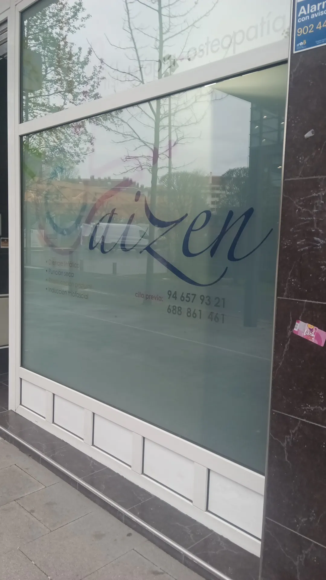 Ventanal con el rótulo de Aizen, centro de fisioterapia y osteopatía.