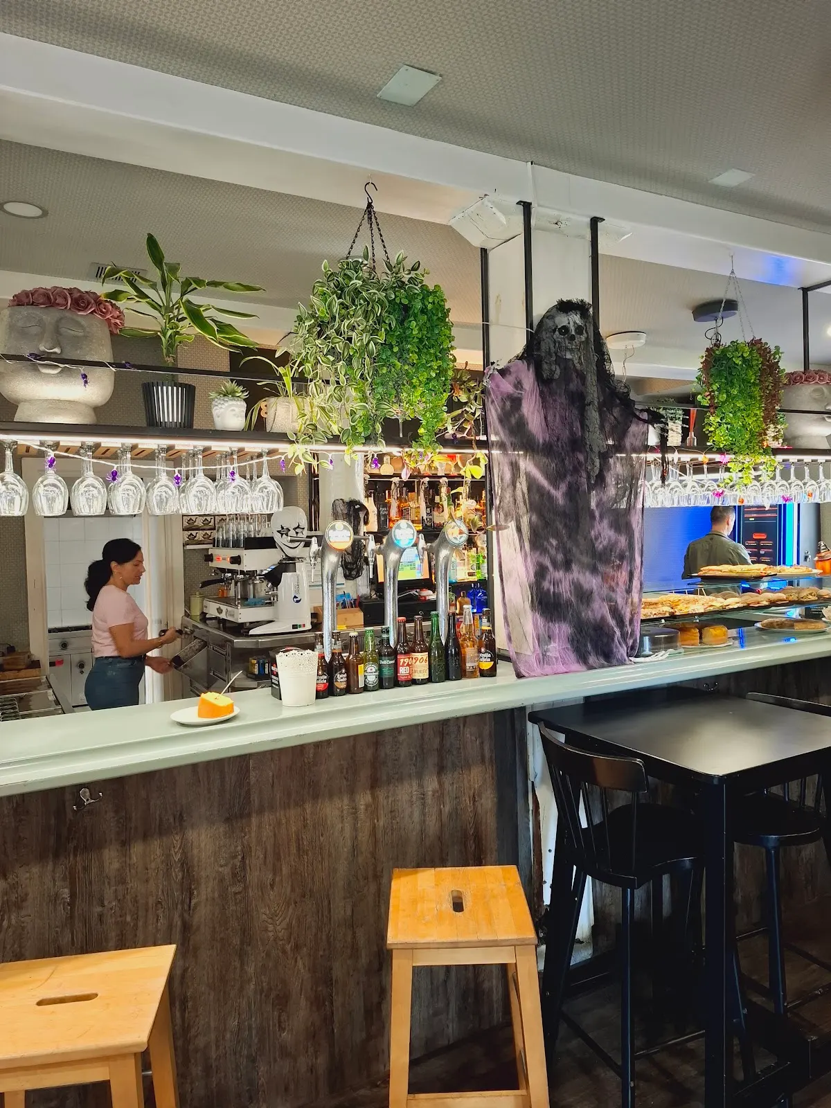 Barra de Aledi...Bar en Berriz, con taburetes, bebidas y plantas colgantes.
