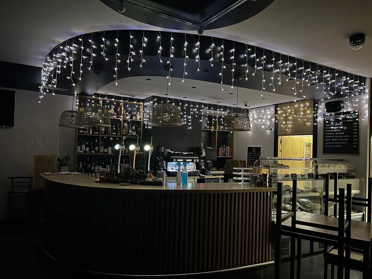 Interior de Aliné Kafe denda, con barra y luces decorativas.