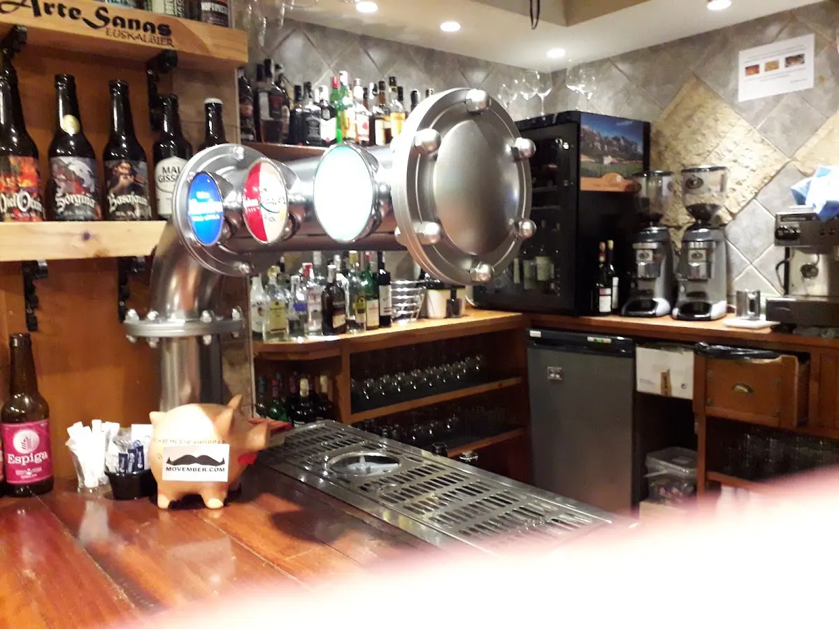 Barra de Alpino Taberna con grifos de cerveza y botellas.