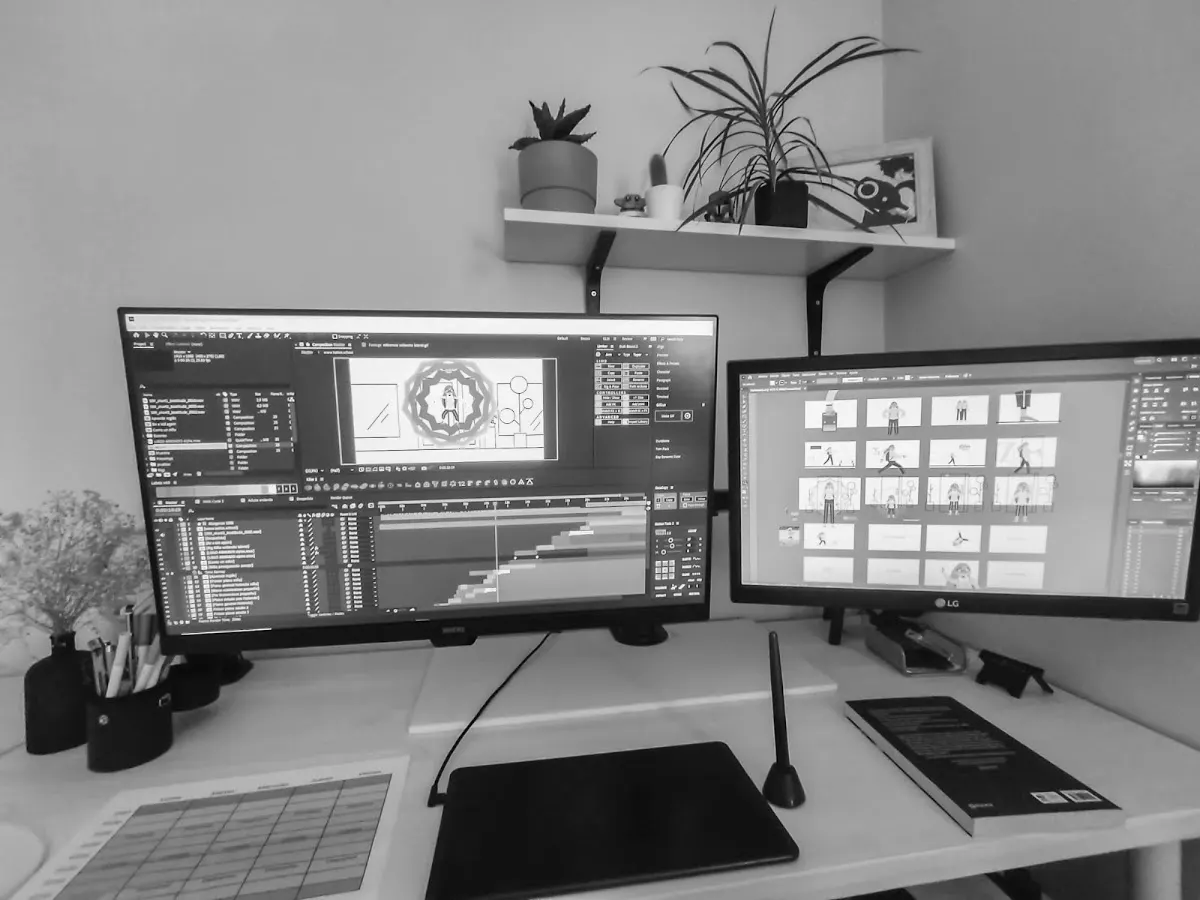 Mesa de trabajo de Amobe con dos monitores y herramientas de diseño