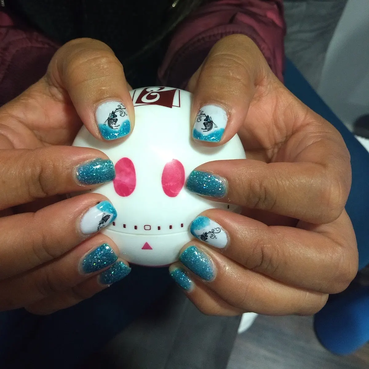 Manicura con esmalte azul y dibujos decorativos