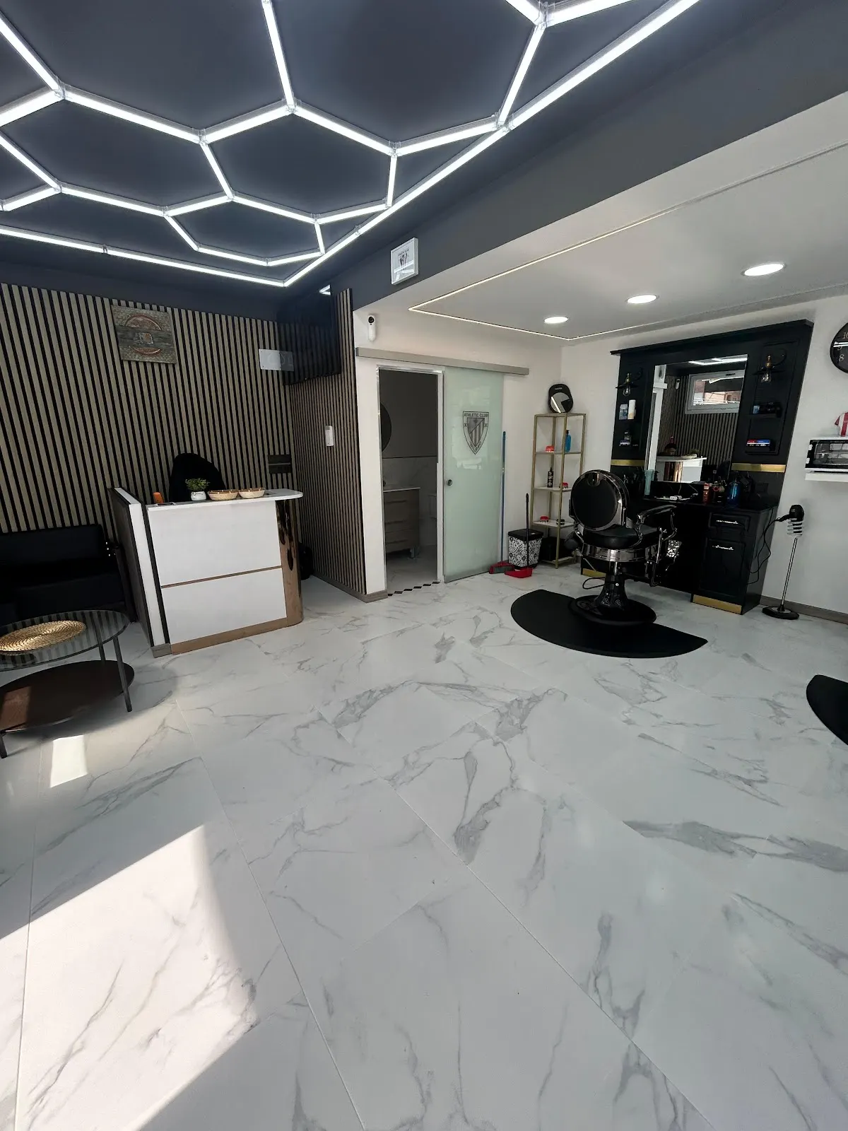 Interior de ANDRES BARBER, con sillones de barbería y mostrador de recepción