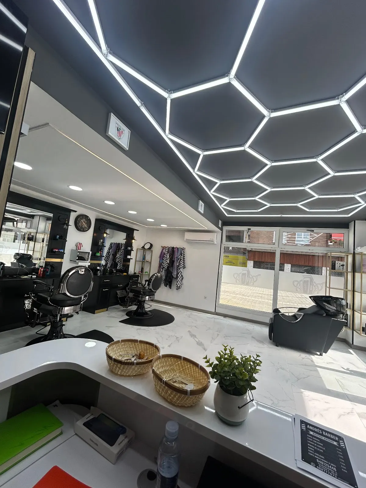 Zona de atención de ANDRES BARBER, con sillones de barbería y escaparate