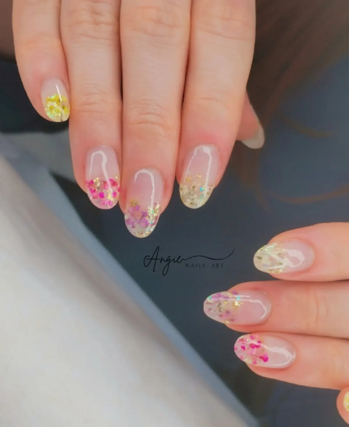 Manos con uñas decoradas con motivos florales y brillo en ANGIE NAILS ART.