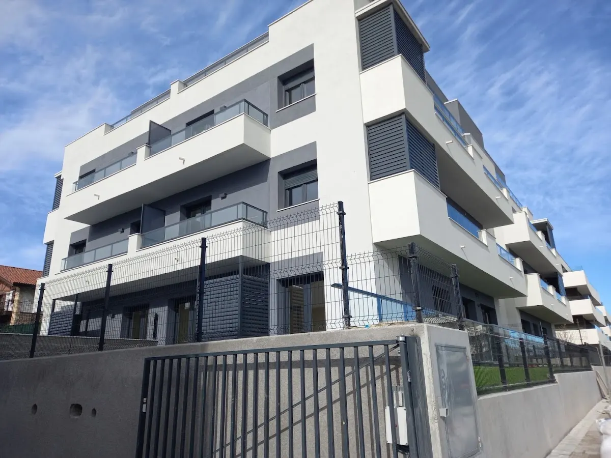 Edificio de viviendas blanco con balcones y cerramiento exterior