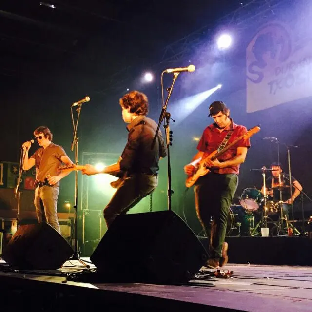 Grupo de música actuando en un escenario.