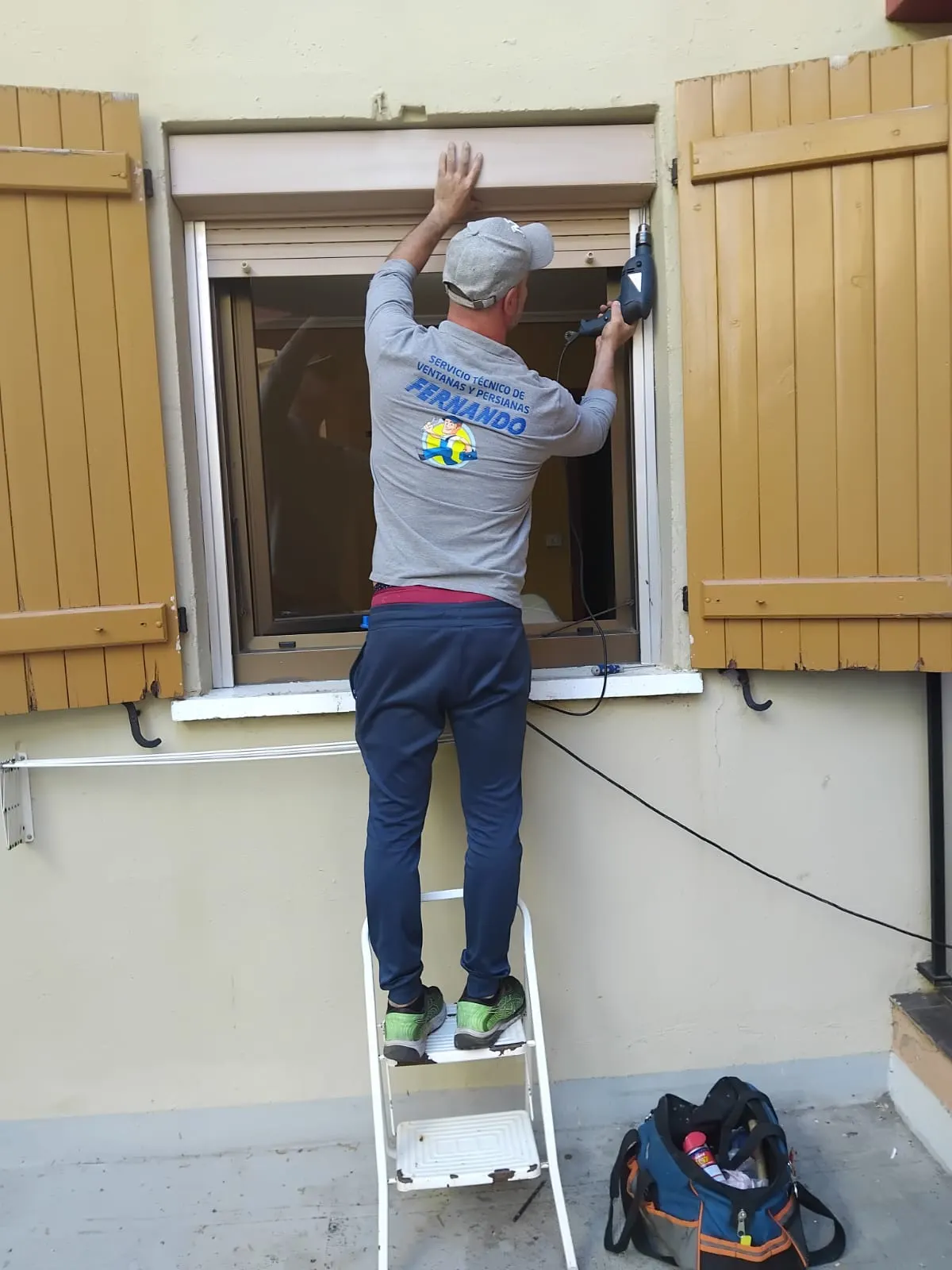 Un técnico ajusta una persiana en una ventana durante una reparación.