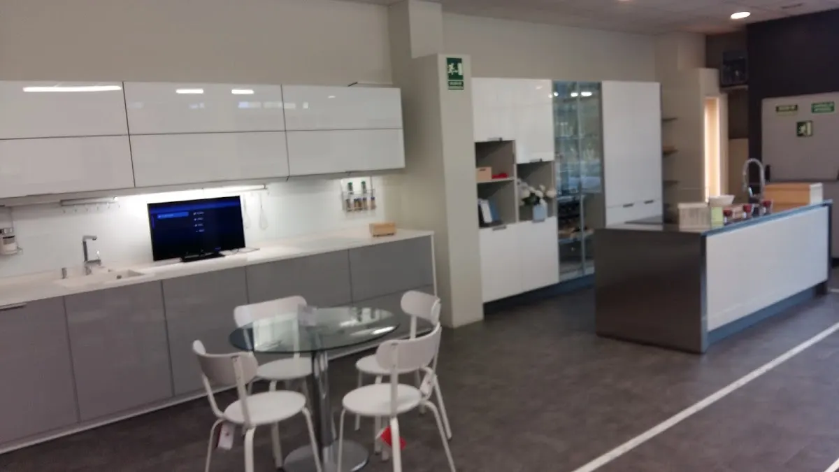 Exposición de cocinas de Arriandi Santos con muebles, encimera y zona de comedor.
