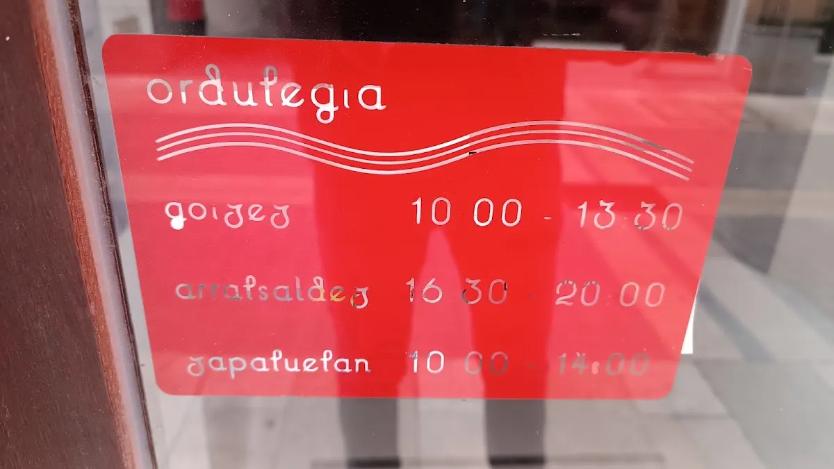 Cartel de horarios de Arteka Liburu Denda en la puerta.
