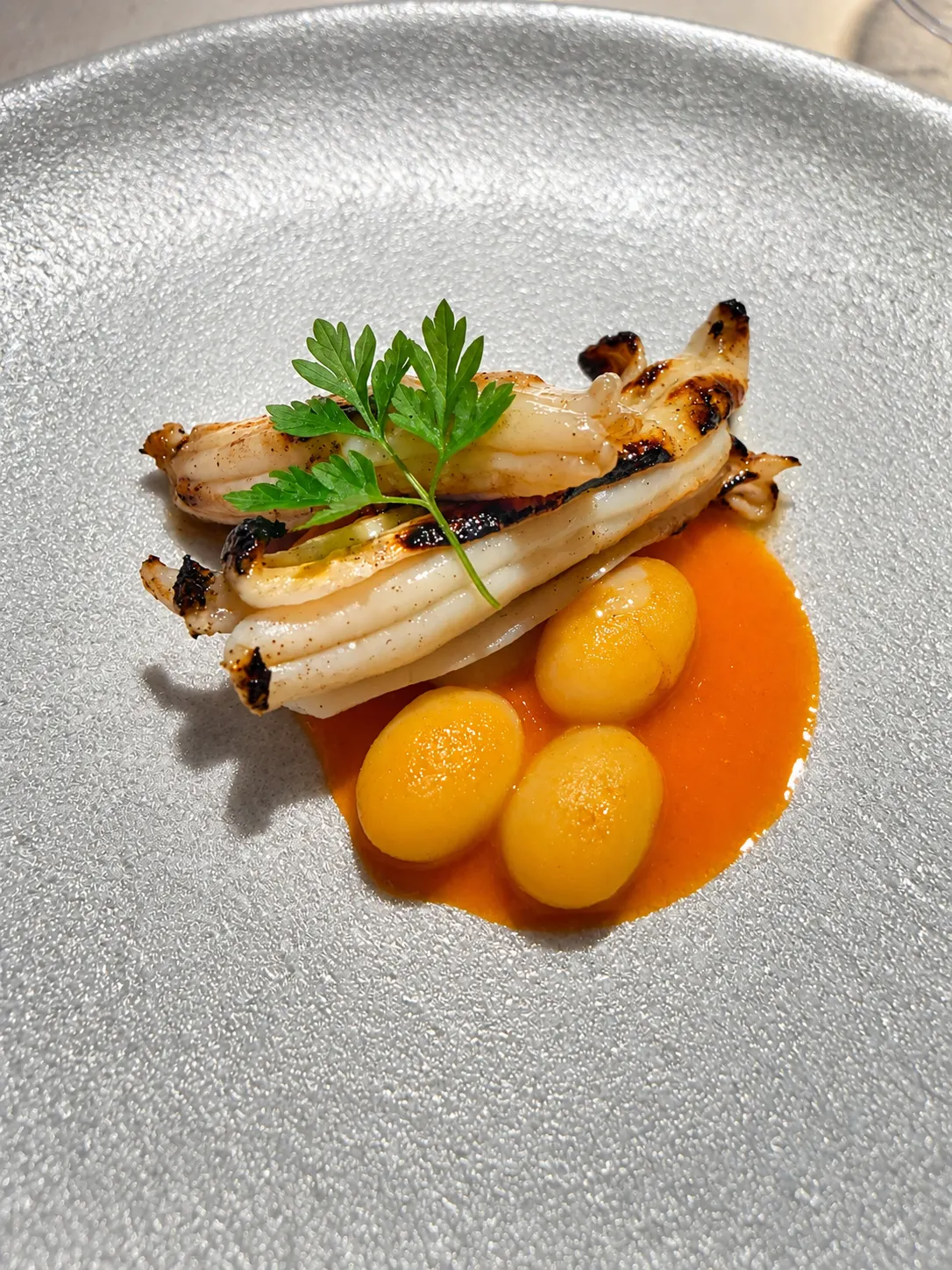Plato de pescado a la brasa con guarnición, servido en Asador Etxebarri.