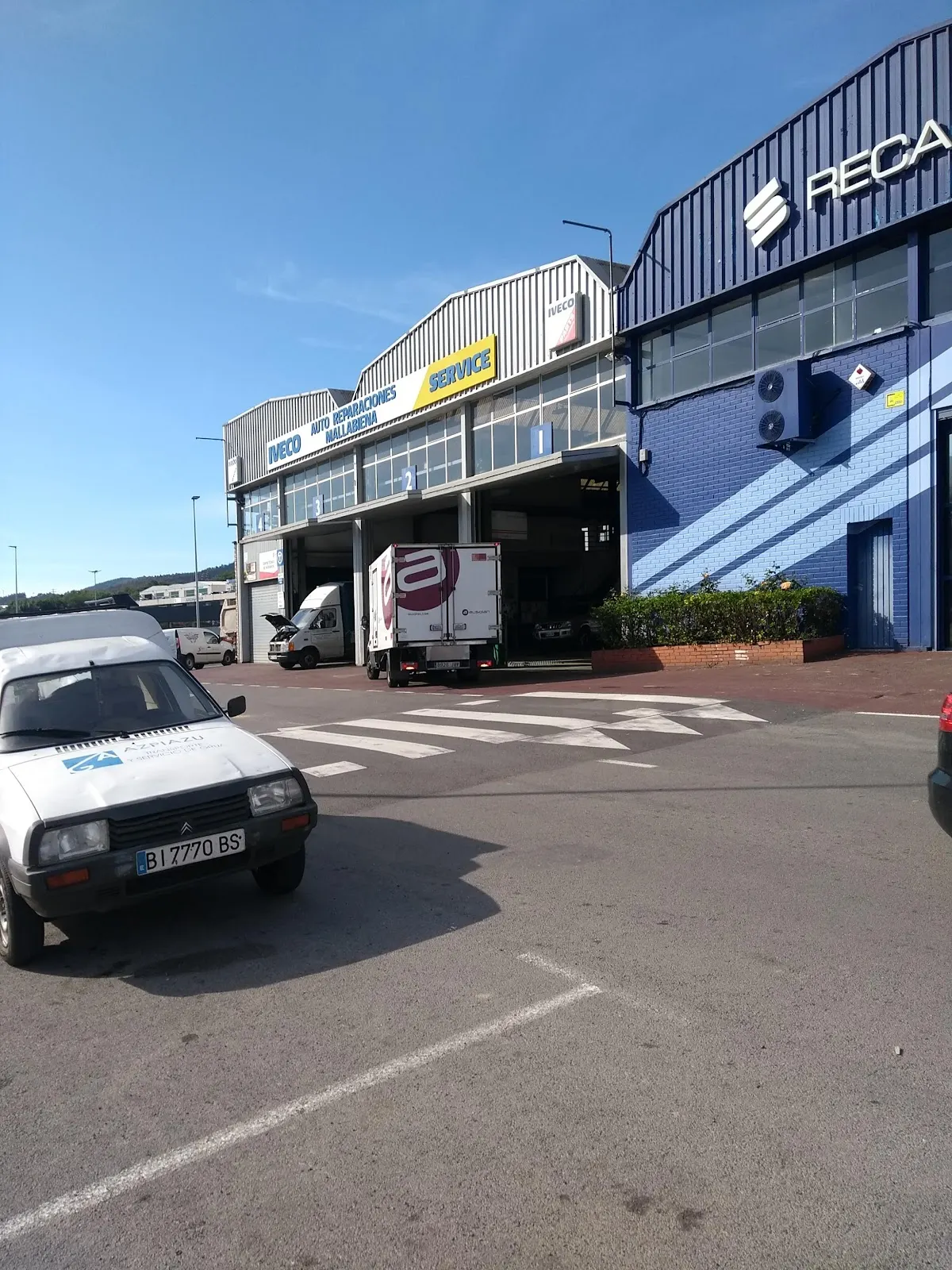 Exterior de Auto-Reparaciones Mallabiena en un polígono, con vehículos en la entrada.