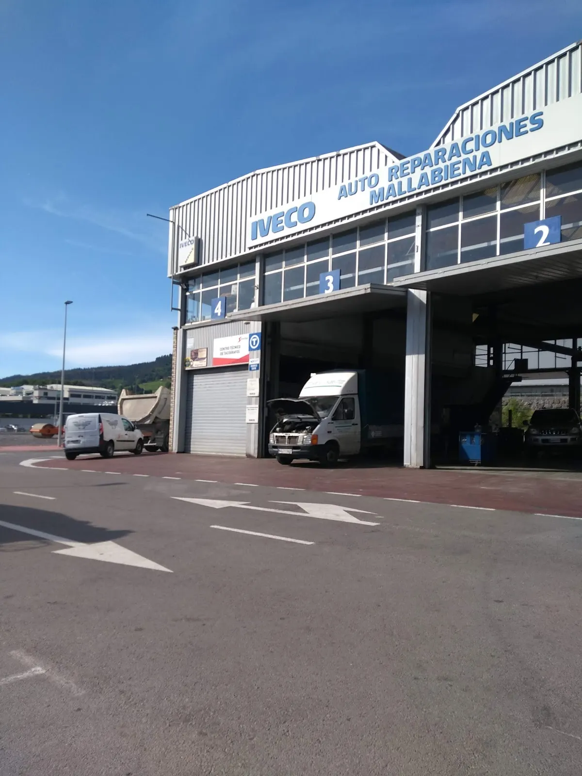 Accesos al taller Auto-Reparaciones Mallabiena, con varios vehículos en las bahías.