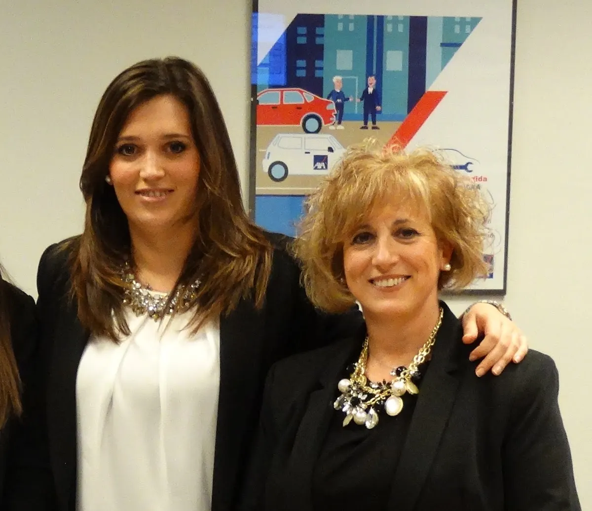 Dos mujeres posan juntas en una oficina de Axa Seguros Adiskide 2000.
