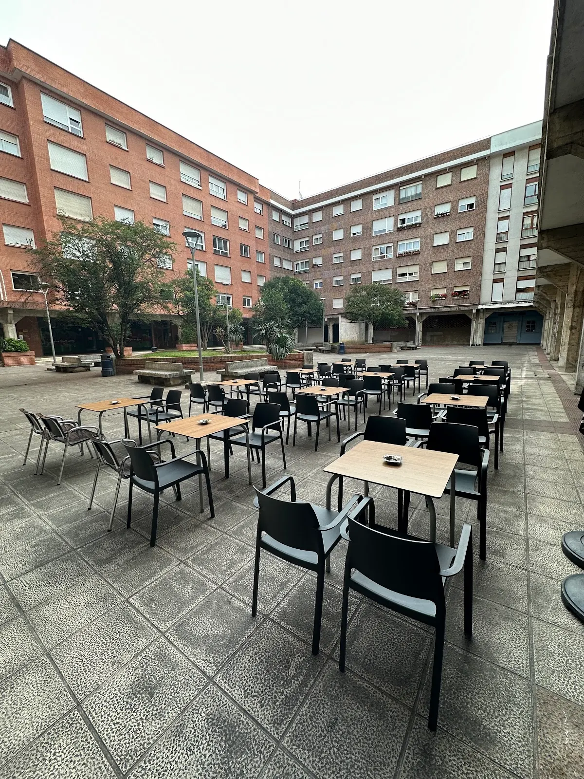 Terraza de Axpe con mesas y sillas en una plaza de Durango