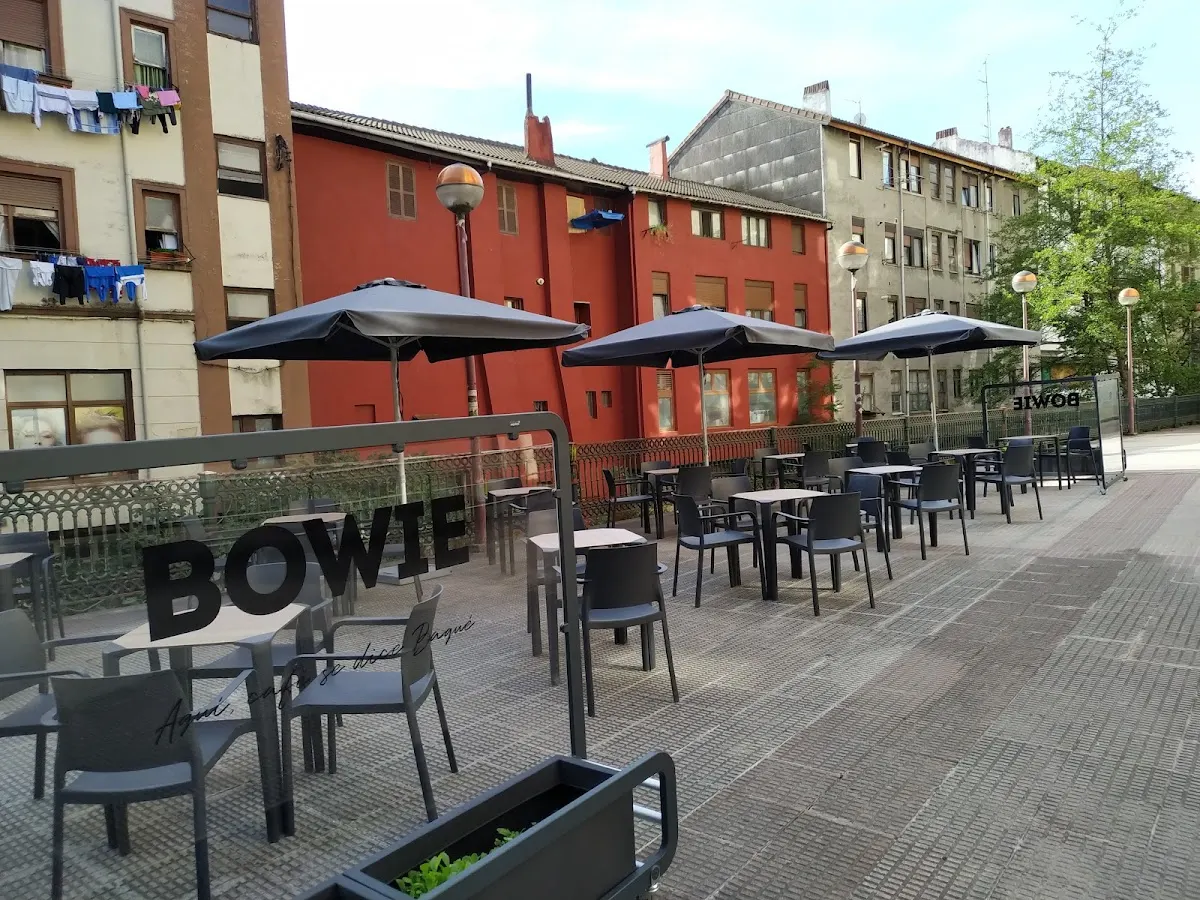 Terraza exterior de Bar Bowie con mesas, sillas y sombrillas