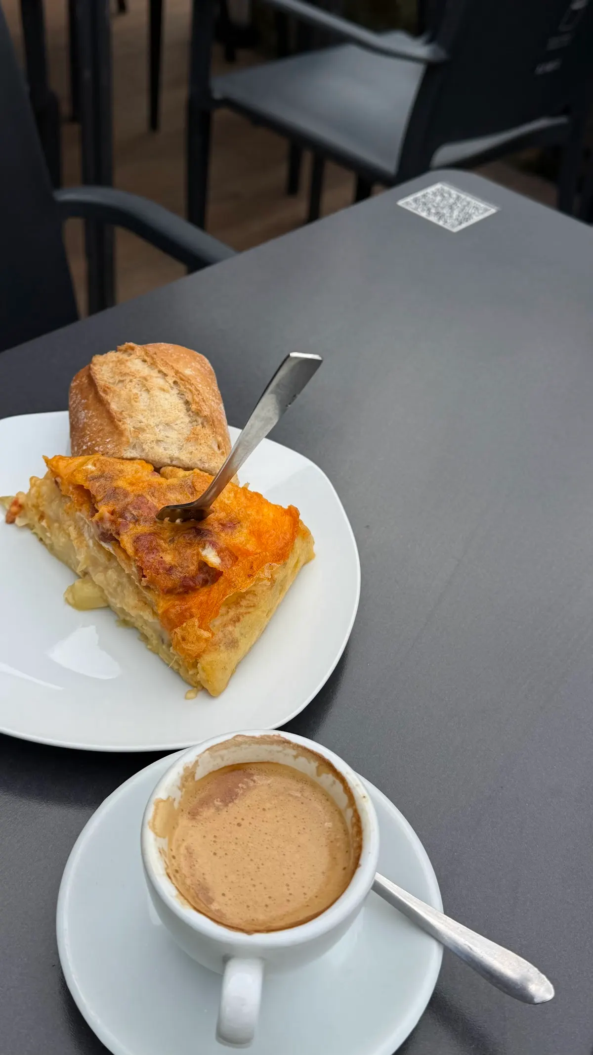 Café y porción de tortilla servidos en una mesa de Bar La Terraza.