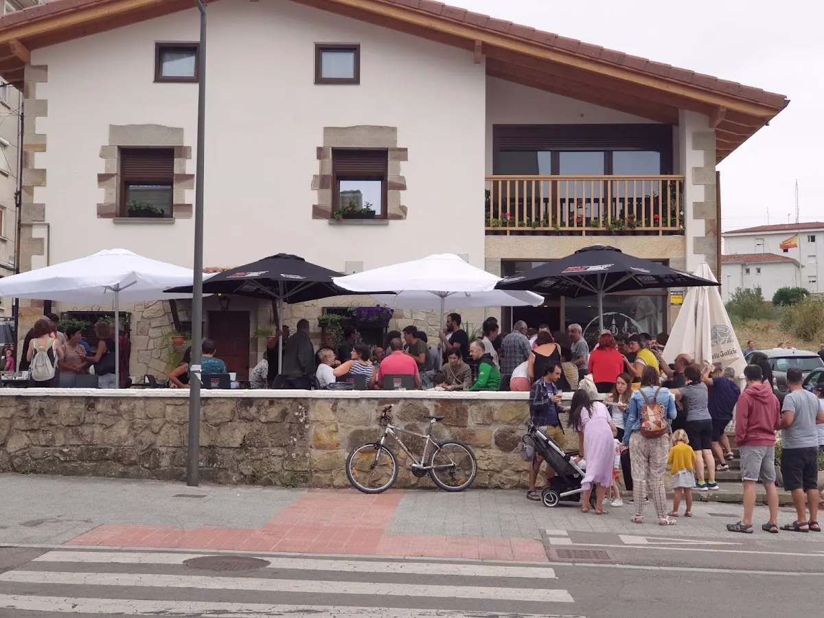 Terraza de Bar La Terraza con clientes sentados bajo sombrillas.
