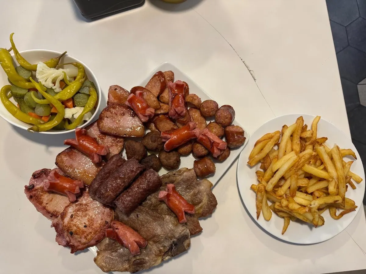 Plato de carnes variadas con patatas fritas y guindillas en Bar Nuevo Pino.
