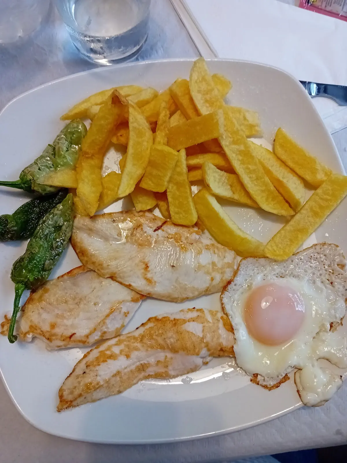 Plato combinado de carne, huevo, patatas fritas y pimientos en el Bar restaurante Ibaizabal.