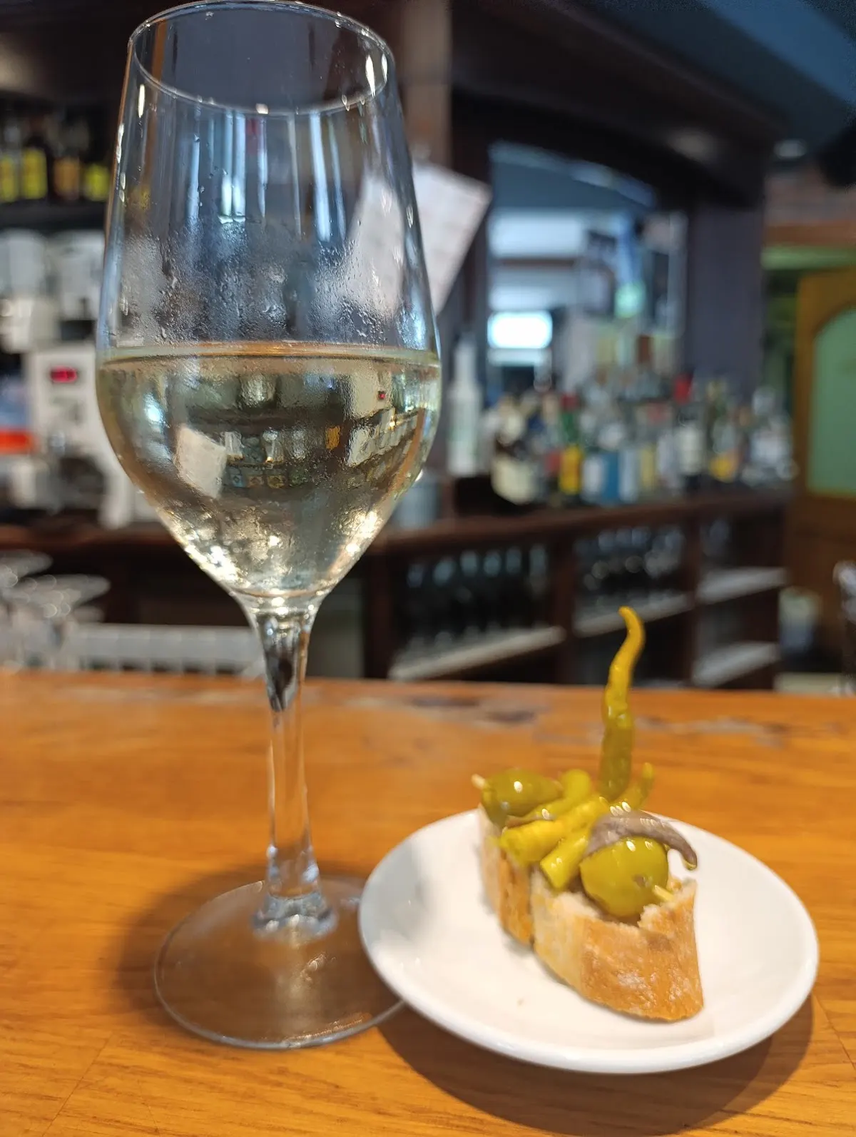 Copa de vino blanco y pintxo sobre la barra del Bar restaurante Ibaizabal.