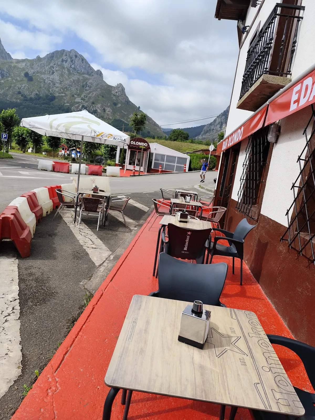 Terraza exterior del Bar restaurante Olondo, con mesas y vistas a la montaña.