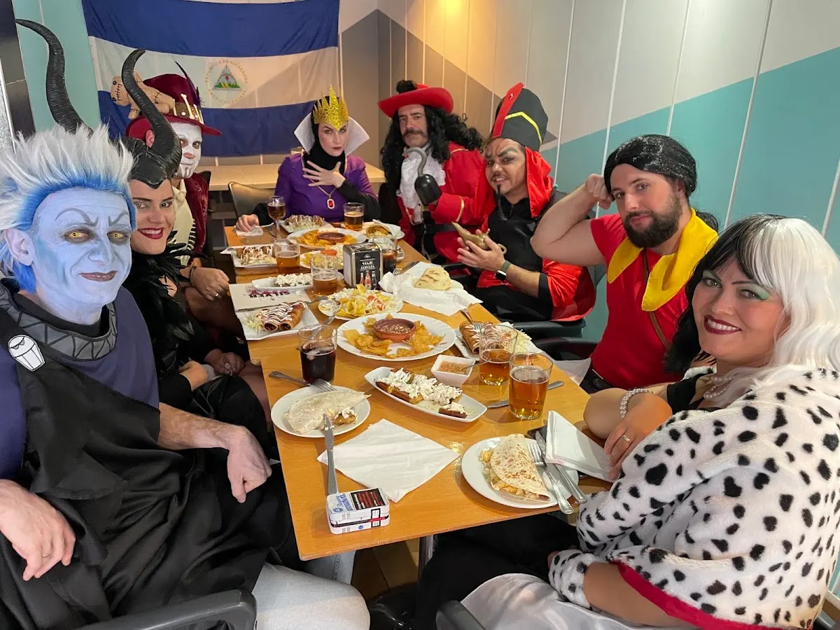 Grupo de personas disfrazadas comparte una comida en Bar Restaurante Silver City Cafe.