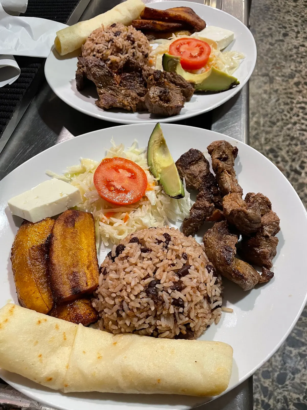 Platos con arroz, carne, plátano, ensalada y otros acompañamientos en Bar Restaurante Silver City Cafe.