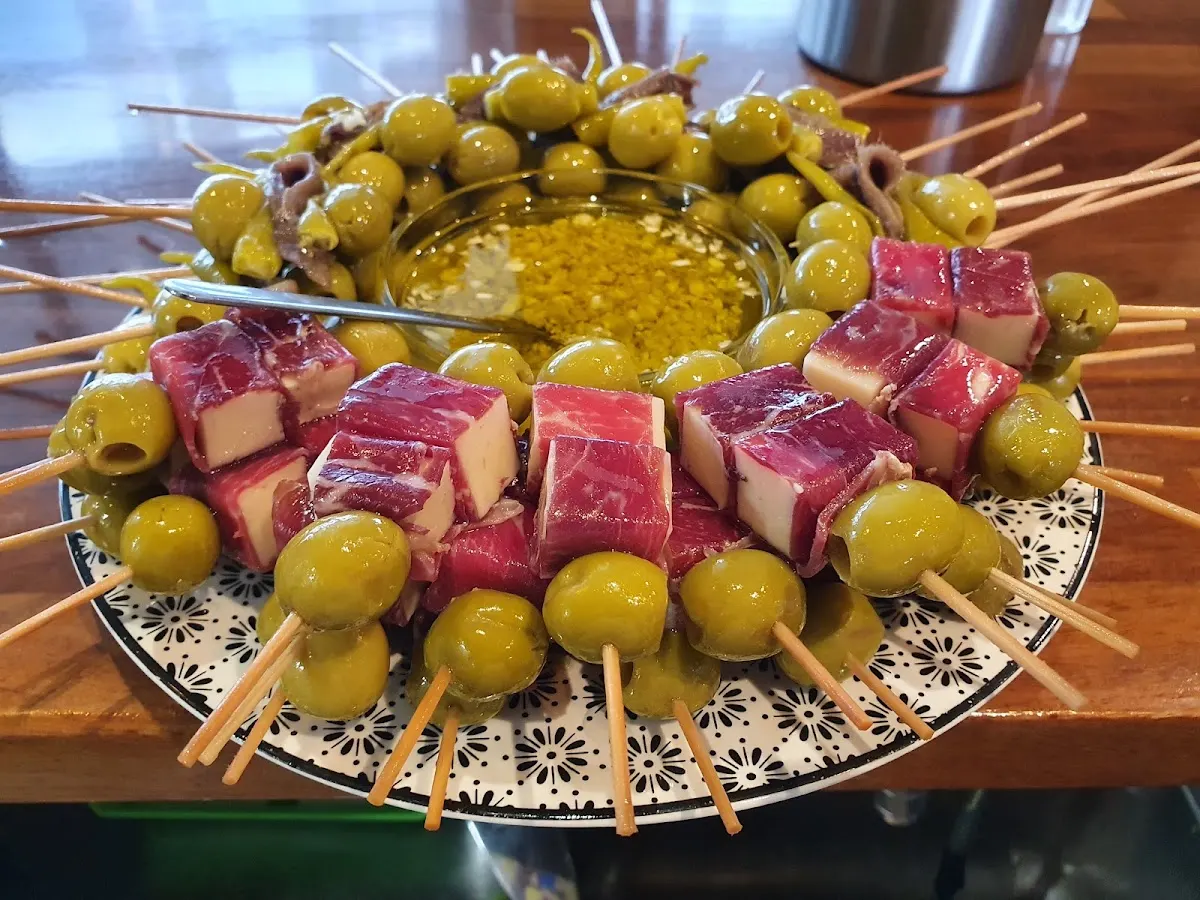 Plato de pintxos de aceitunas y queso con palillos en Bar SORGIN.