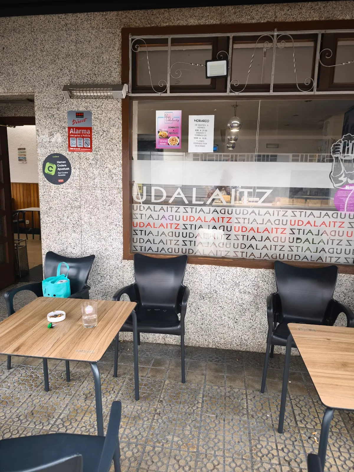 Mesas y sillas de la terraza de Bar Udalaitz frente al ventanal