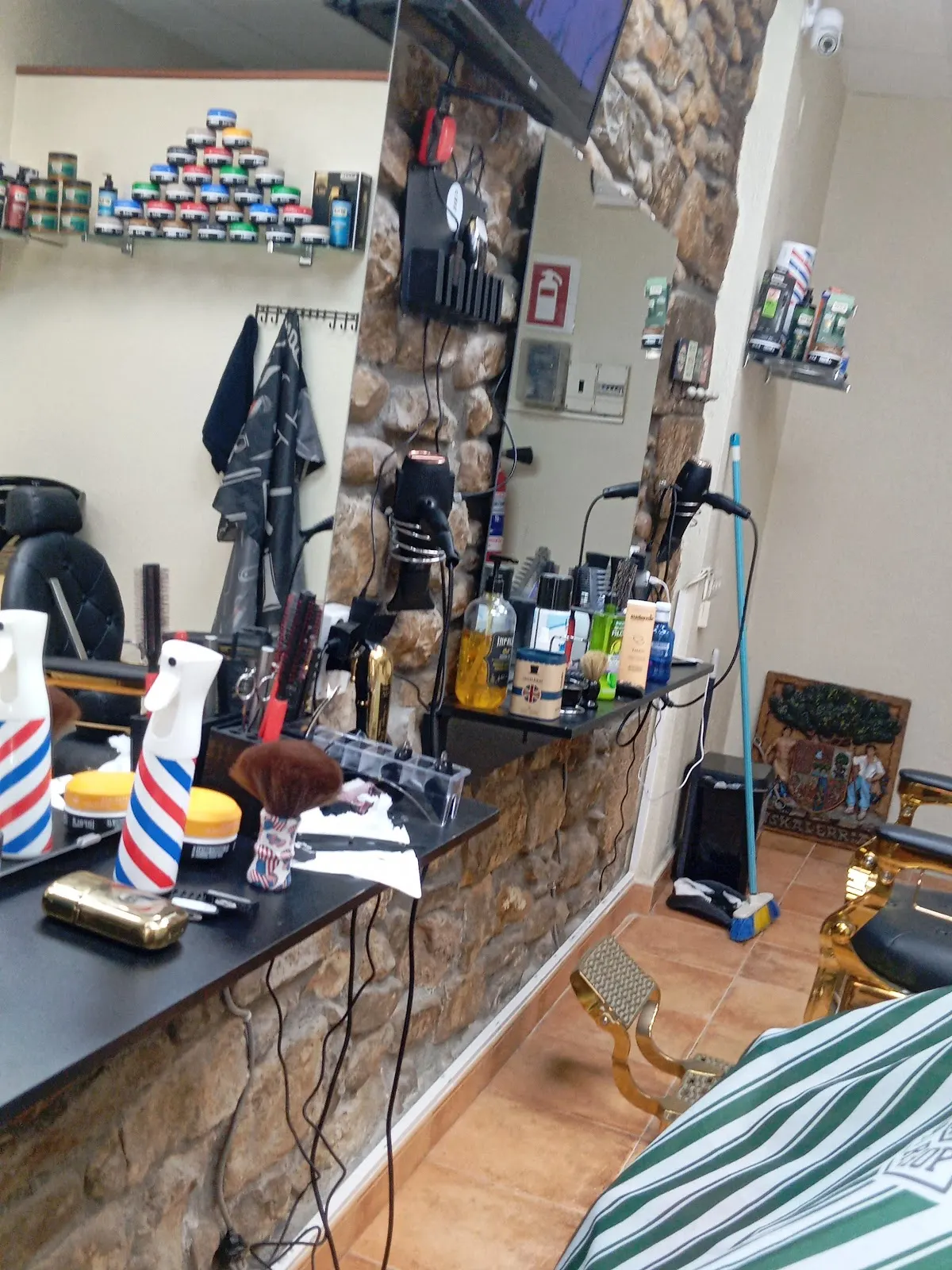 Interior de BARBER SHOP JM con sillones y puestos de barbería