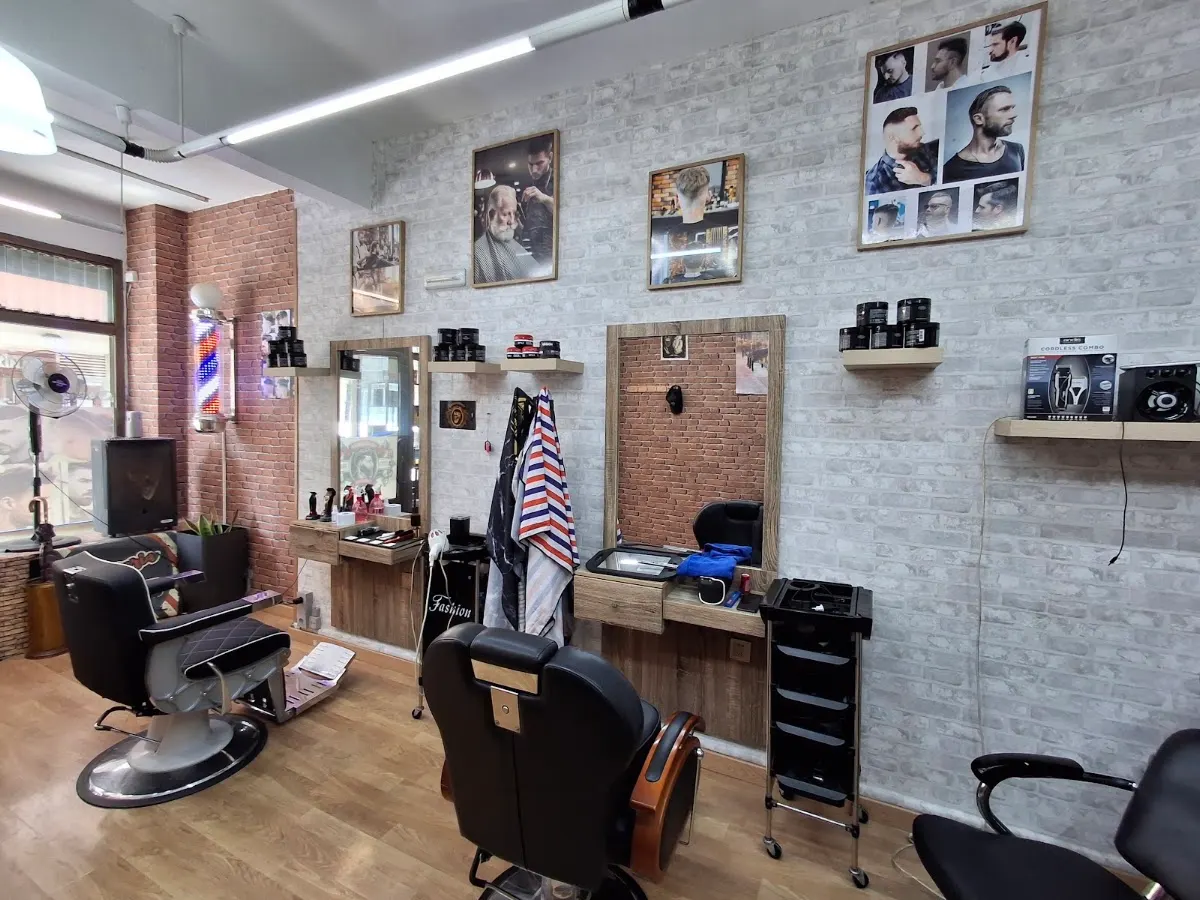 Interior de Barbería Bader con sillones y puestos de barbería.