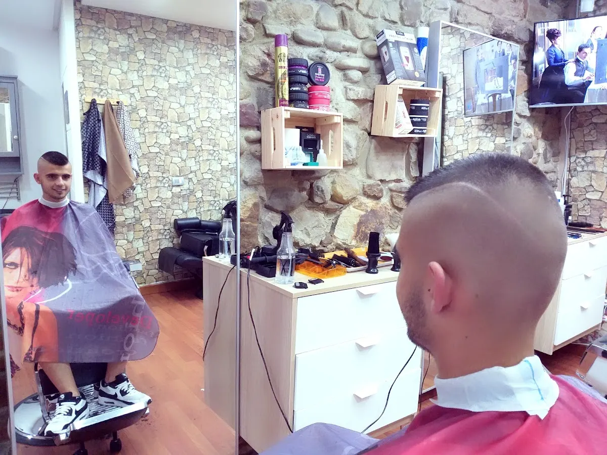 Interior de Barberlandako Mohsin Andra Mari con un cliente en la silla de barbería.