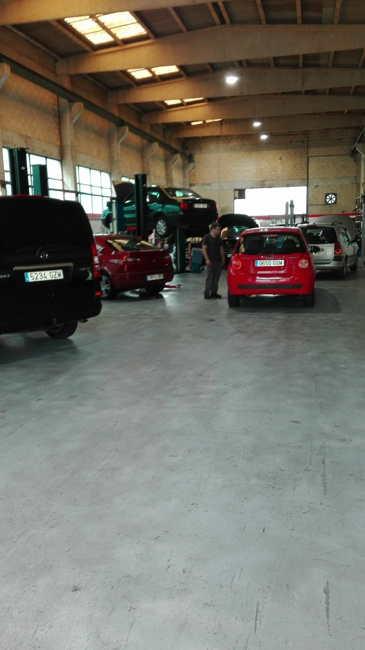 Interior de Berriz Motor Sport con varios coches en reparación.