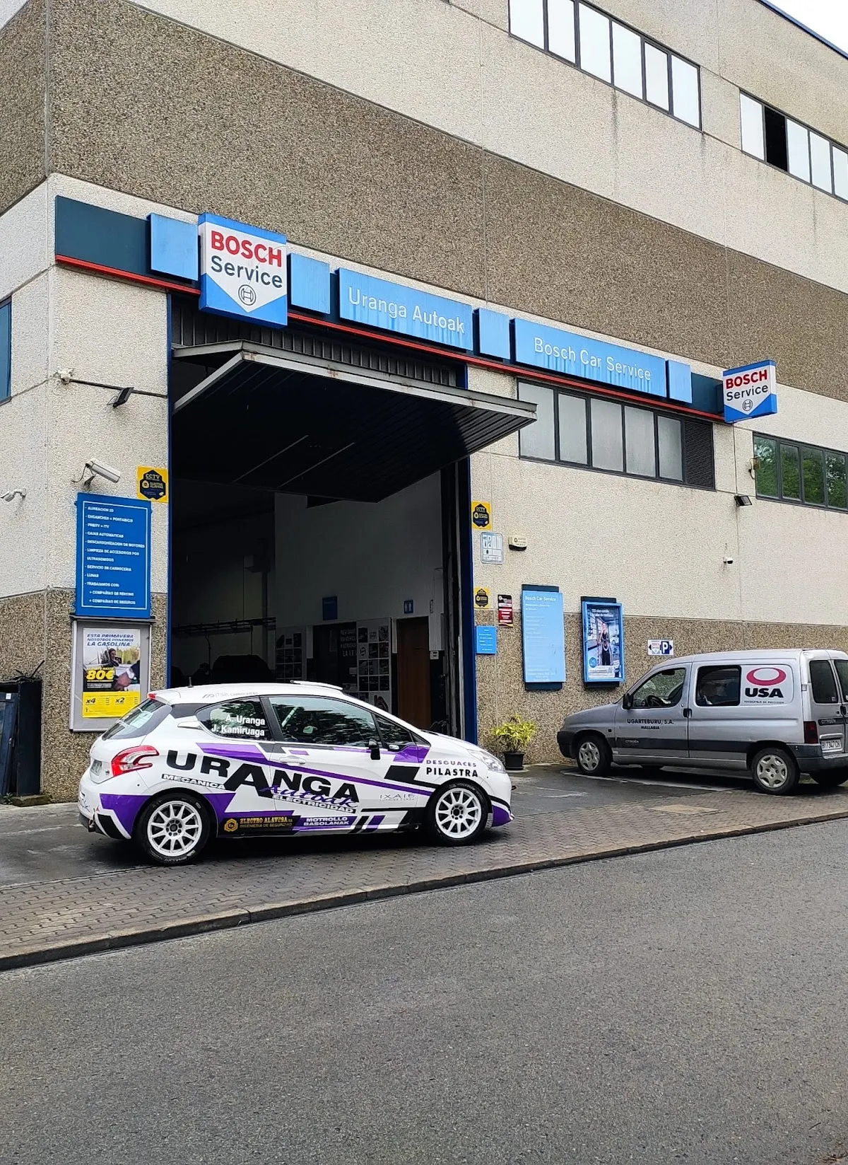 Fachada del taller Bosch Car Service - Uranga Autoak en Mallabia, con un coche rotulado frente a la entrada.