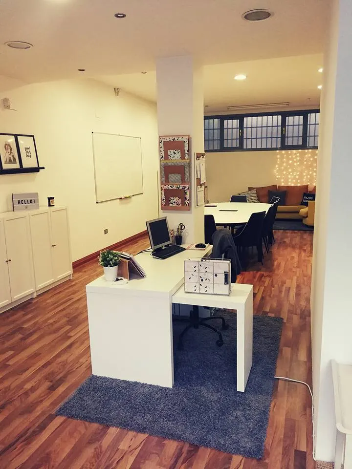 Interior de Bristol English Studio con mesas, sillas y zona de trabajo.
