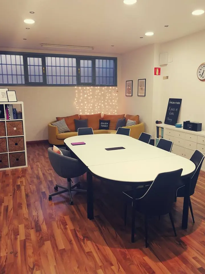 Sala de Bristol English Studio con una mesa de reuniones y un espacio de descanso.
