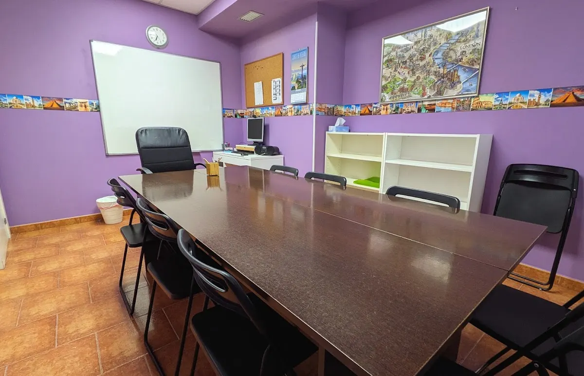 Aula de Bvrns Academy con mesa de reuniones, pizarra y estanterías.