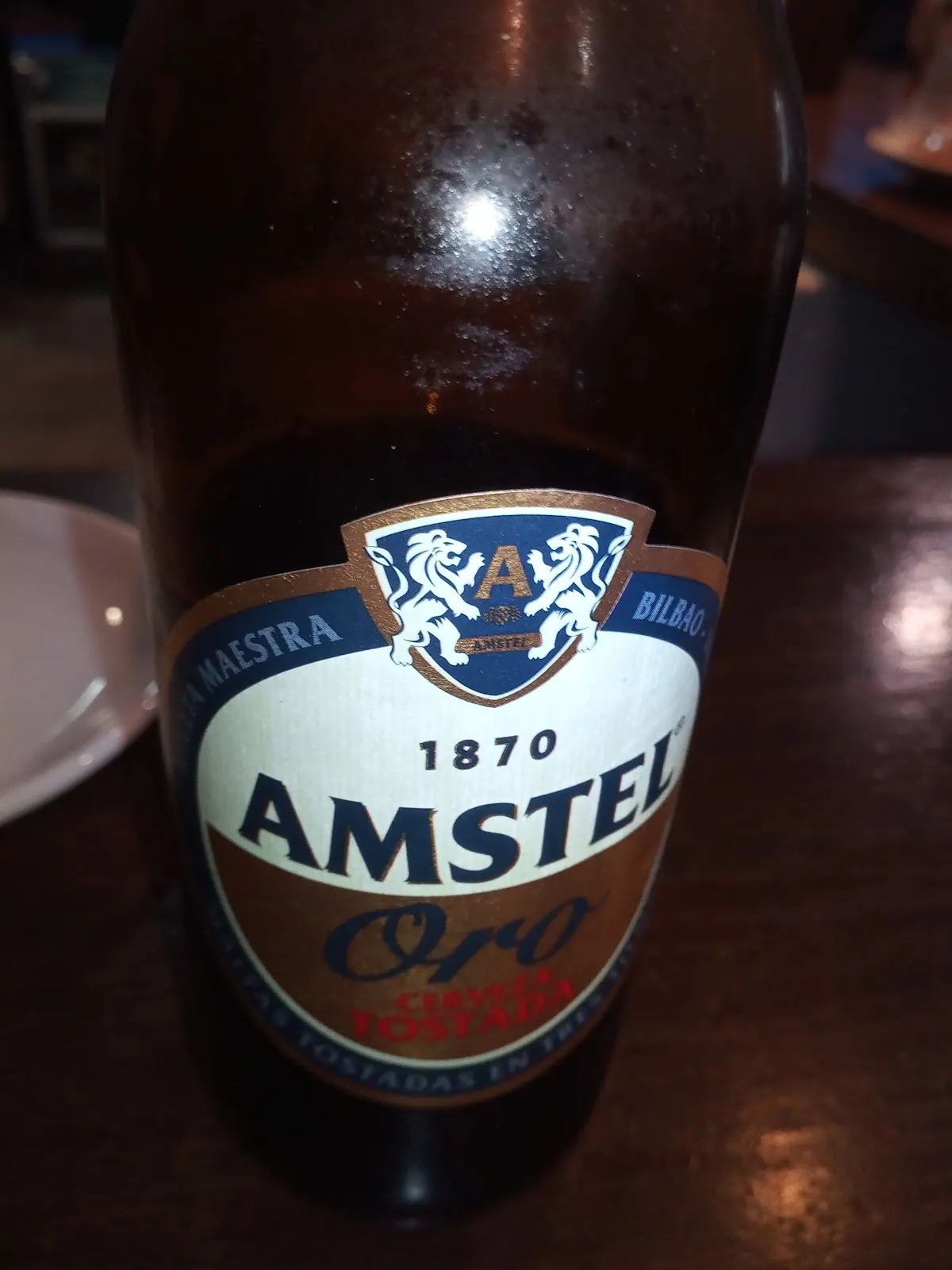 Botella de cerveza Amstel sobre una mesa.