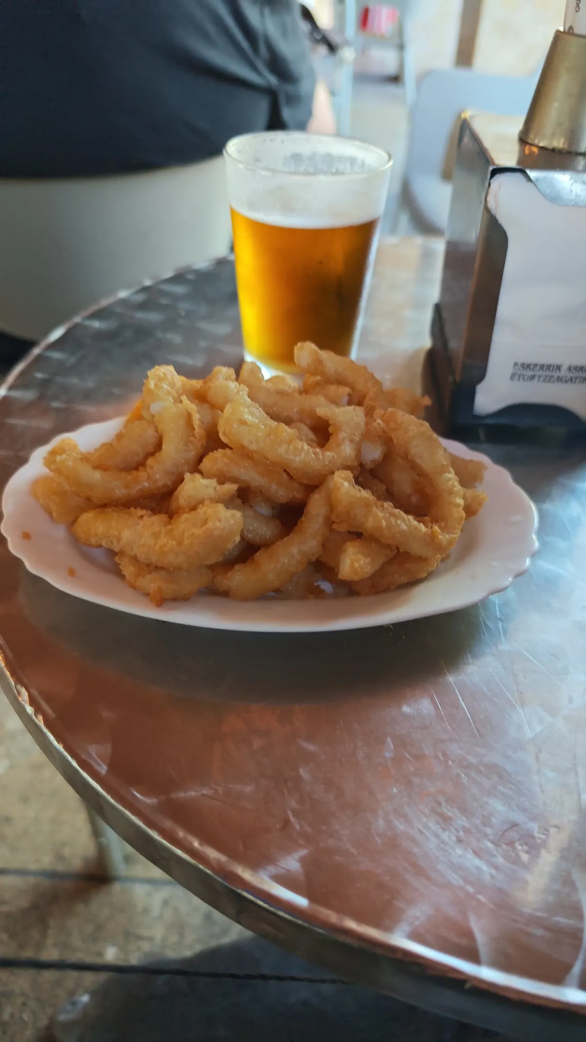 Ración de fritos y cerveza en una mesa de la Cafetería Jai-toki.