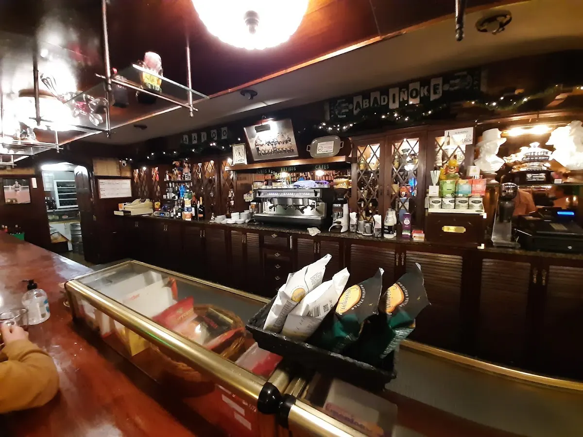 Interior de la barra de Cafetería Oxford, con vitrinas, bebidas y máquina de café.