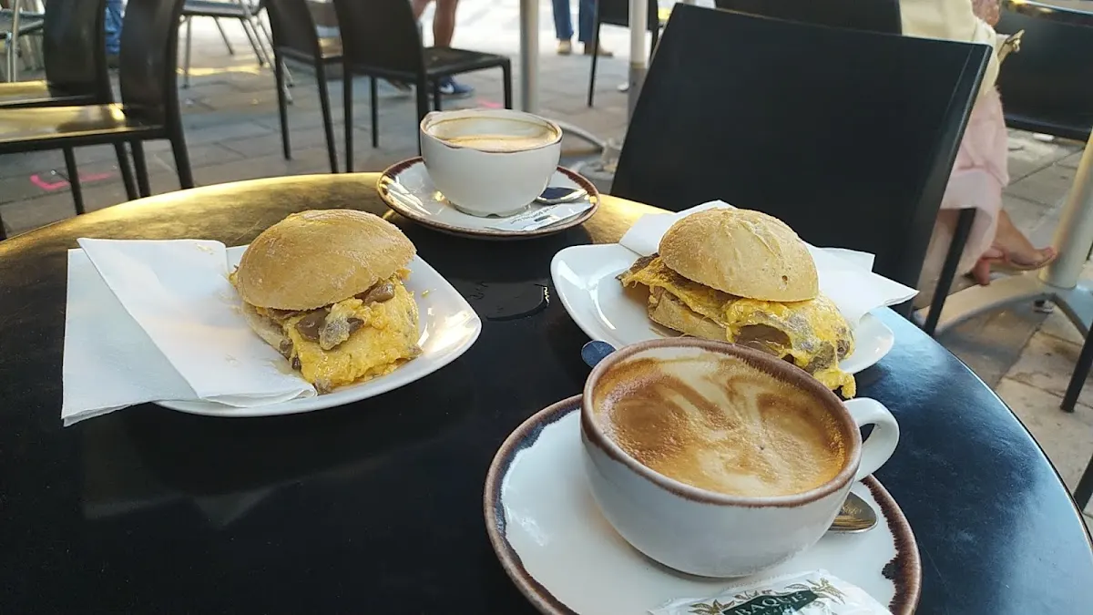 Cafés y pequeños bocadillos servidos en una mesa de Cafetería Pausta.