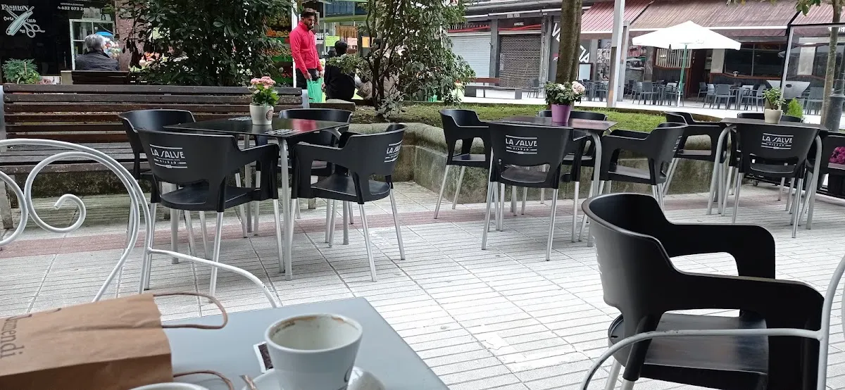 Terraza exterior de Cafetería Venecia con mesas y sillas.