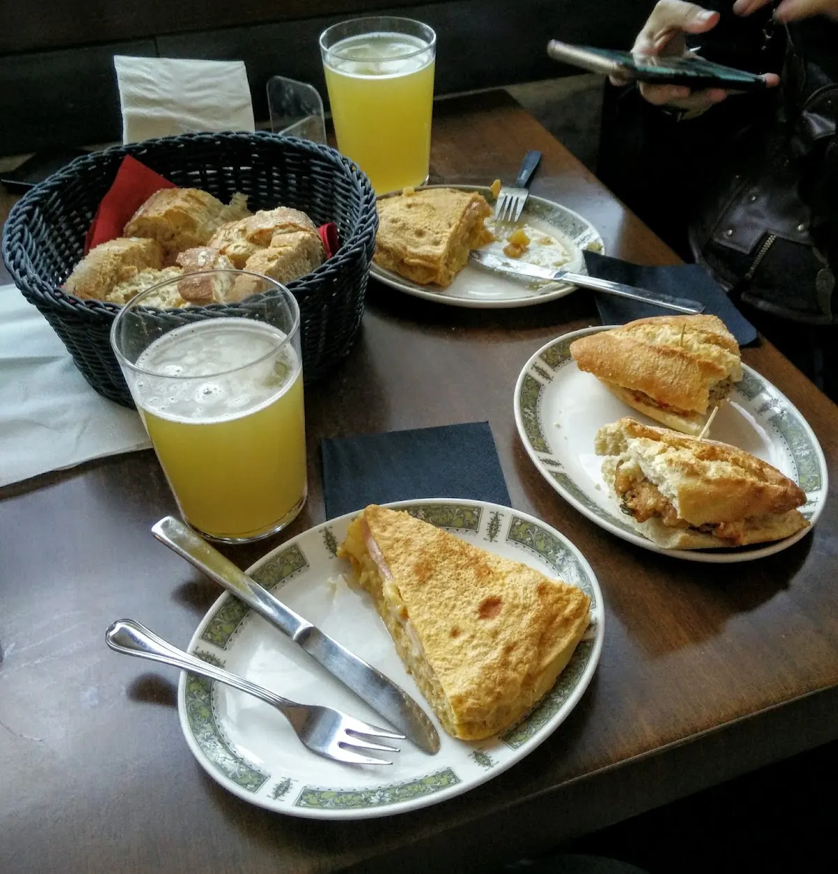 Platos con pintxos y tortilla, y vasos de bebida en Cafetería Venecia.